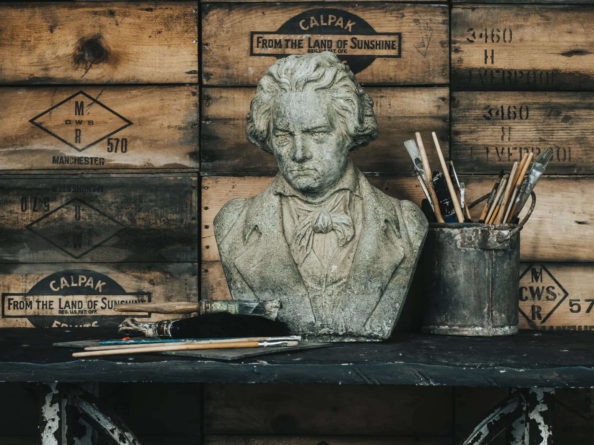 Statue and painting brushes on table