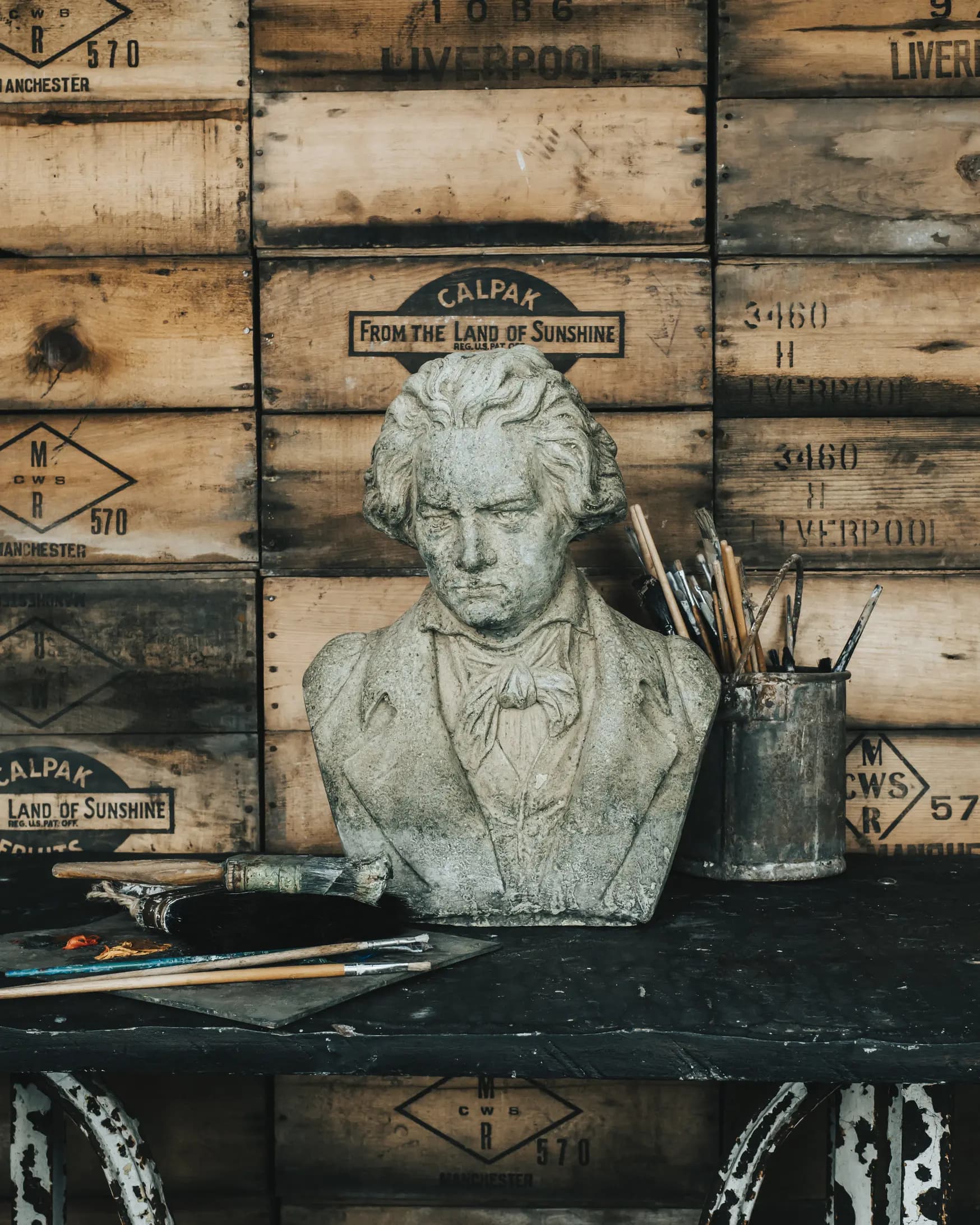 Statue and painting brushes on table